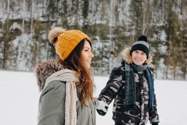 The happy couple in love at the forest nature park in cold season