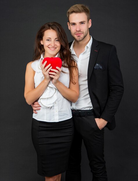 Happy couple in love hold red heart on black background valentines day