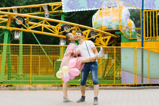 Happy couple in love is having fun at an amusement park in the summer Valentine's day