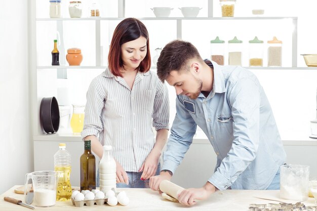 Happy Couple in love kneading dough in the kitchen