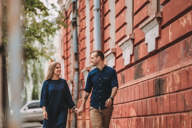 Happy couple in love walks the city streets together. A lovely couple on the old narrow streets of the city. Lifestyle of smiling people. Family relations concept