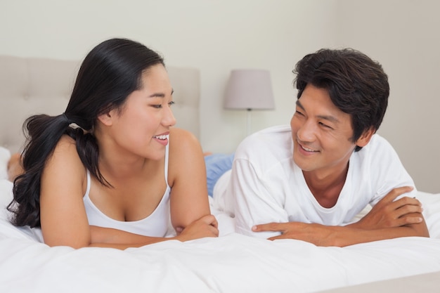 Happy couple lying on bed together