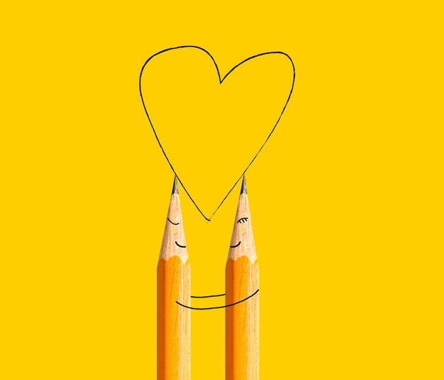 Photo a happy couple made of pencils with painted smiley and hugging drawing a heart shape creative love