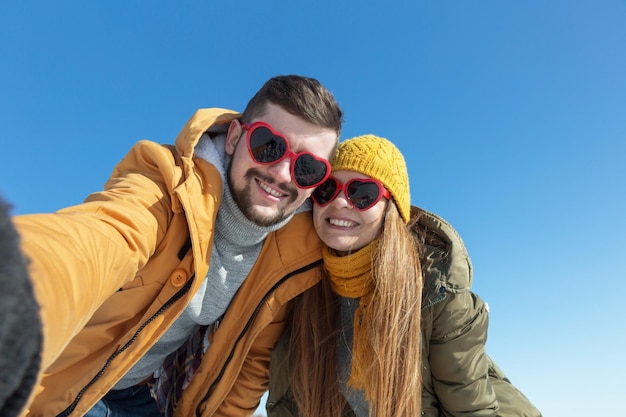 Happy couple making selfie on a winter sunny day Wide angle copy space