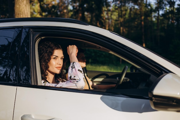 The happy couple man and woman in car traveling in summer