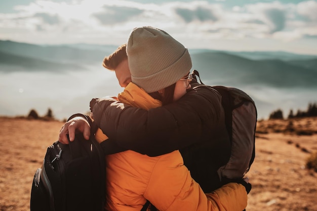 happy couple man and woman tourist at top of mountain during a hike in summer