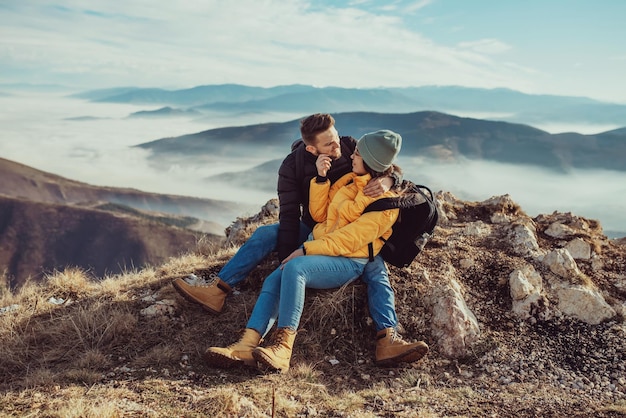 Happy couple man and woman tourist at top of mountain during a hike in summer