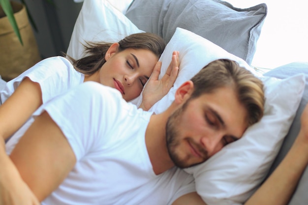 Happy couple sleeping in a comfortable bed at home