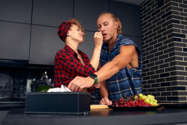 Happy couple standing in kitchen at home preparing together yummy dinner on first dating spouses chatting enjoy warm conversation and cooking process caring for health eating fresh vegetable salad