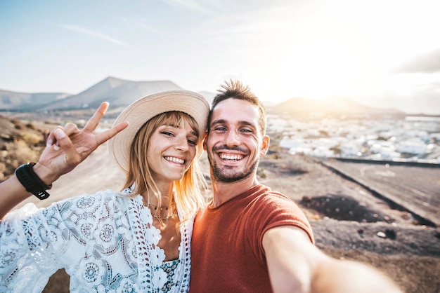 Happy couple taking selfie outside on vacation