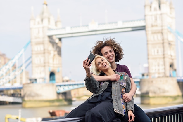 Happy couple taking selfie photograph at the Tower Bridge