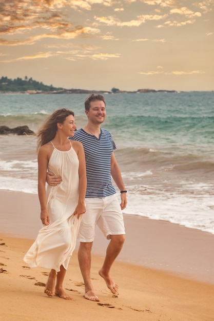 Happy couple together hugging having on tropical sandy beach at sea background Lovely man and woman relaxing happiness