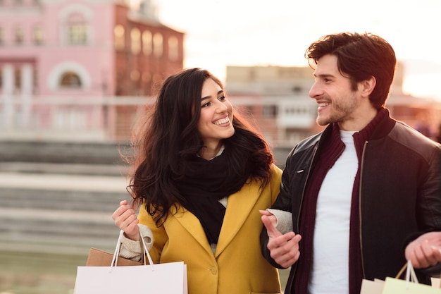 Happy couple walking after shopping enjoying cool autumn day