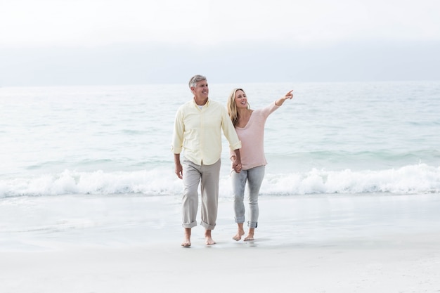 Happy couple walking by the sea