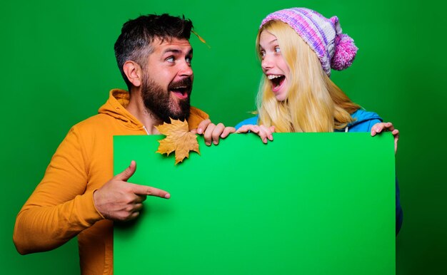 Happy couple with advertising board autumn sales fashion trends for fall black friday