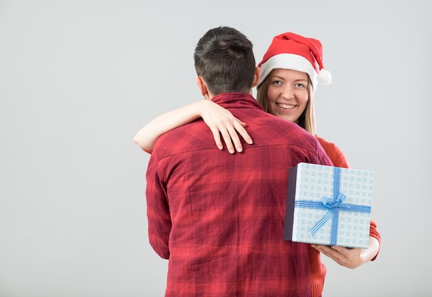 Happy couple with christmas present isolated over gray background