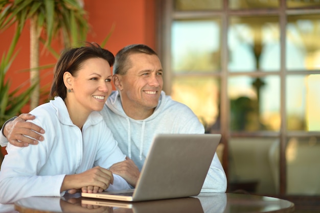 Happy couple with laptop on a sofa