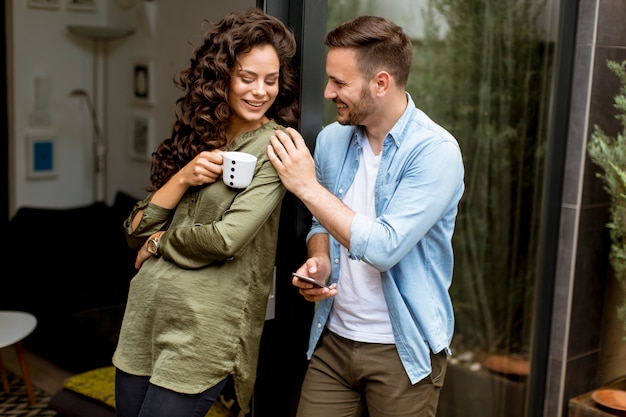 Happy cute couple in love embracing each other and drinking coffee