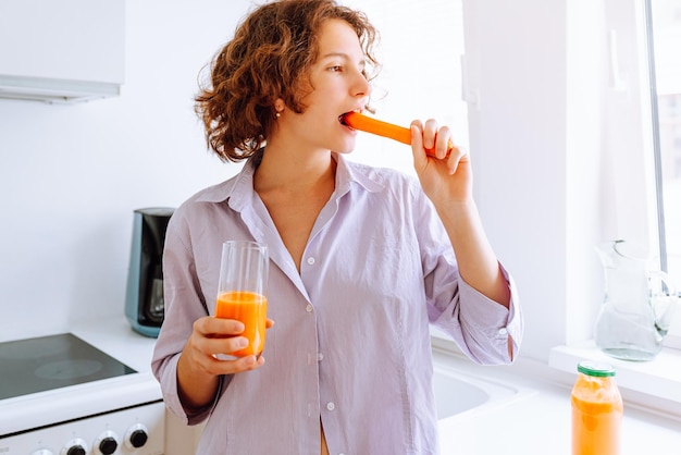 Happy cute girl eating carrot, vitamin A for good vision, health