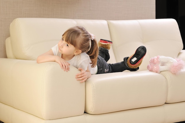 happy cute little girl relax  on sofa at home