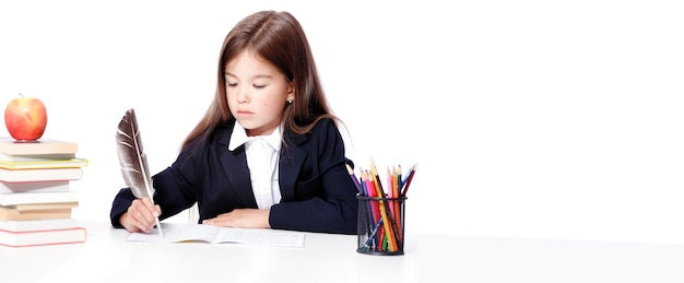 Happy and cute teen school girl writes in a book or notebook