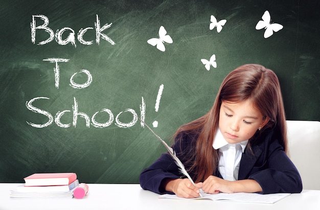 Happy and cute teen school girl writes in a book or notebook