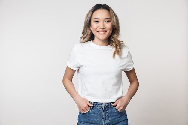 a happy cute young woman posing isolated over white wall wall