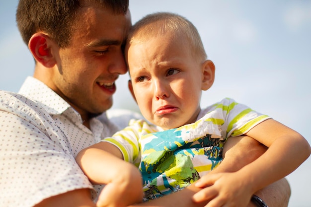 Happy dad comforts his little crying sonPaternity