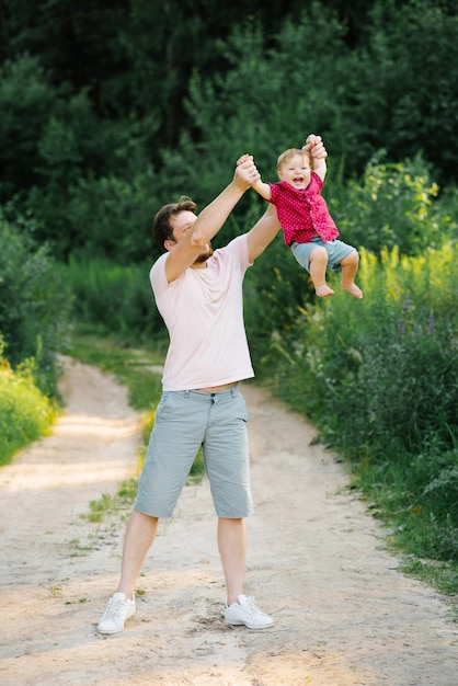 Happy dad having fun with his little son tossing him up