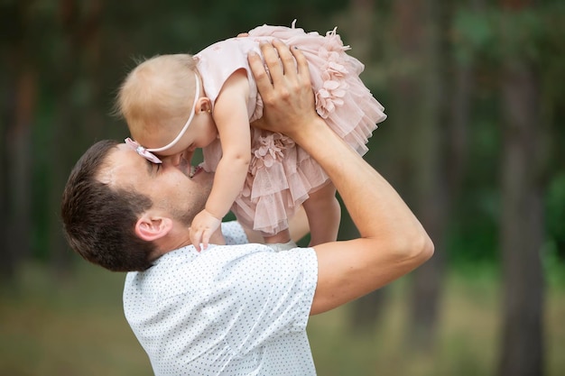 Happy dad throws up with his little daughter for a walk Paternity