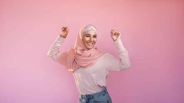 Happy dance good mood success celebration joyful optimistic carefree woman in hijab having fun