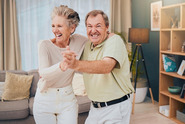 Happy dance and senior couple in a living room smile and fun while being silly in their home together Happy family love and man with woman dancing laughing and goofy while enjoying retirement