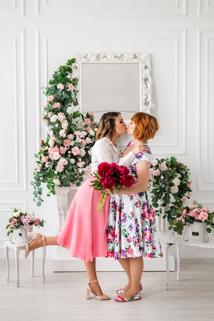 Happy daughter giving mother a spring flower bouquet