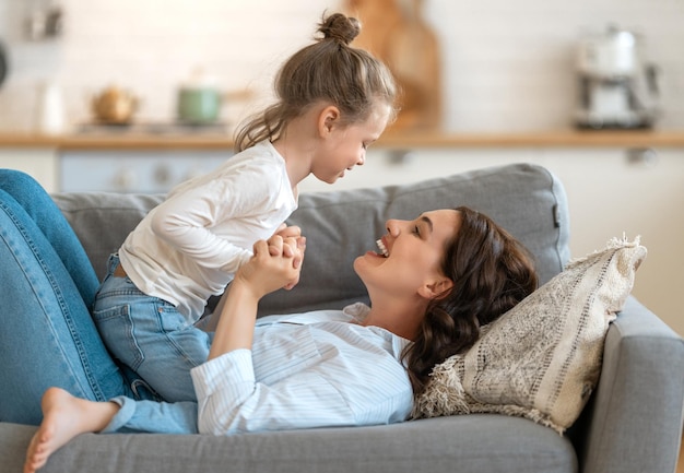 Happy day! Mom and her daughter child girl are playing, smiling and hugging. Family holiday and togetherness.