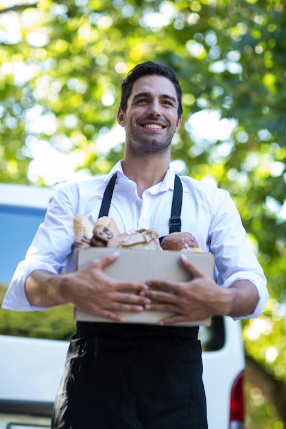 Happy delivery person carrying food package