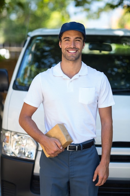 Happy delivery person holding cardboard box 