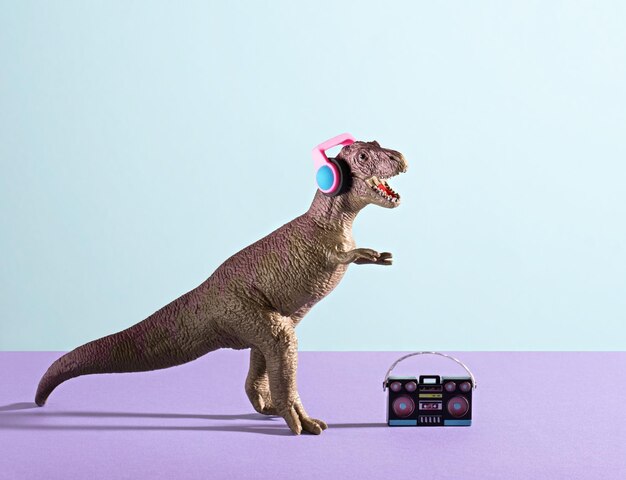 Happy dinosaur with headphones and tape recorder on blue violet background