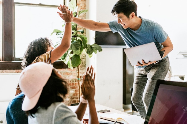 Happy diverse colleagues in a startup company doing a high five