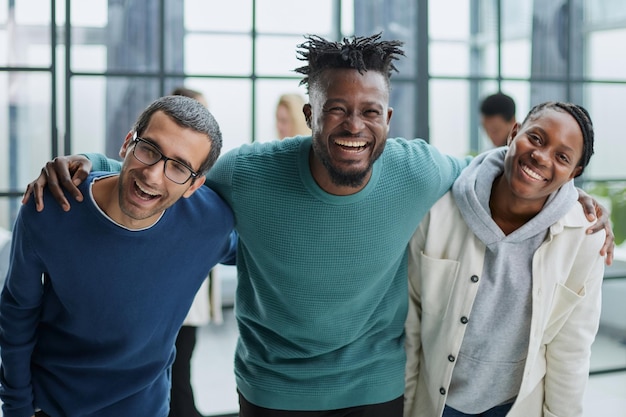 Happy diverse professional business team standing in the office and looking at the camera smiling