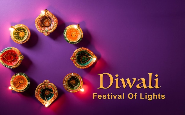 Happy Diwali Clay Diya lamps lit during Dipavali Hindu festival of lights celebration Colorful traditional oil lamp diya on purple background