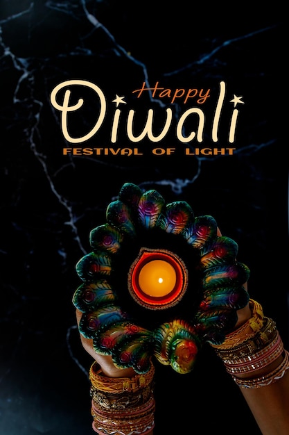 Happy Diwali - Woman hands with henna holding lit candle isolated on dark background. Clay Diya lamps lit during Dipavali, Hindu festival of lights celebration. Copy space for text.