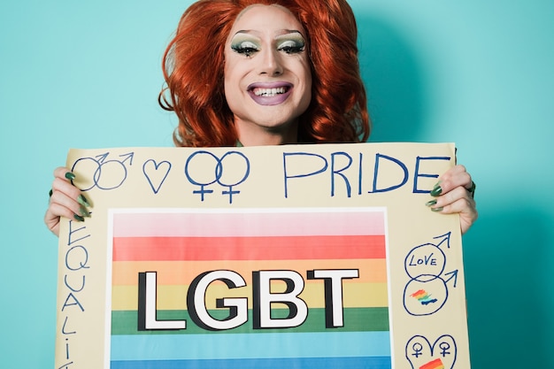 Photo happy drag queen holding lgbt banner - focus on face