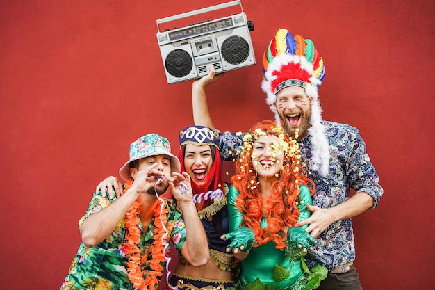 Happy dressed people celebrating at carnival party throwing confetti - Main focus on right girl face