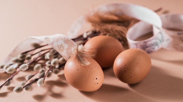 Happy Easter card with natural color eggs and feathers on beige background