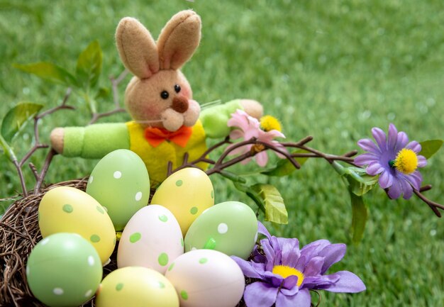 Happy Easter Colorful eggs in a nest on green grass close up view