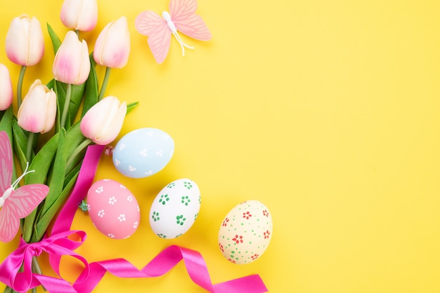 Happy easter! Colourful of Easter eggs in nest with pink tulip flower