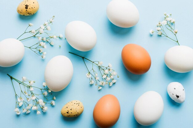 Happy Easter composition Easter eggs on colored table with gypsophila Natural dyed colorful eggs background top view with copy space