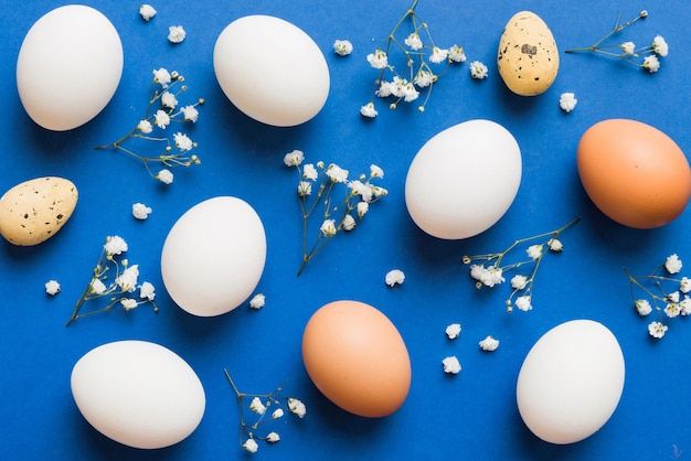 Happy Easter composition Easter eggs on colored table with gypsophila Natural dyed colorful eggs background top view with copy space