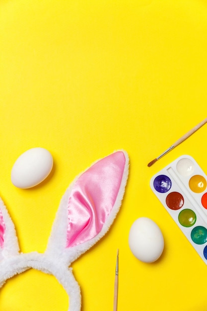 Happy easter concept preparation for holiday decorative eggs colorful paints and bunny ears furry co