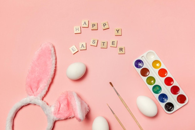 Happy easter concept preparation for holiday inscription happy easter letters eggs colorful paints a